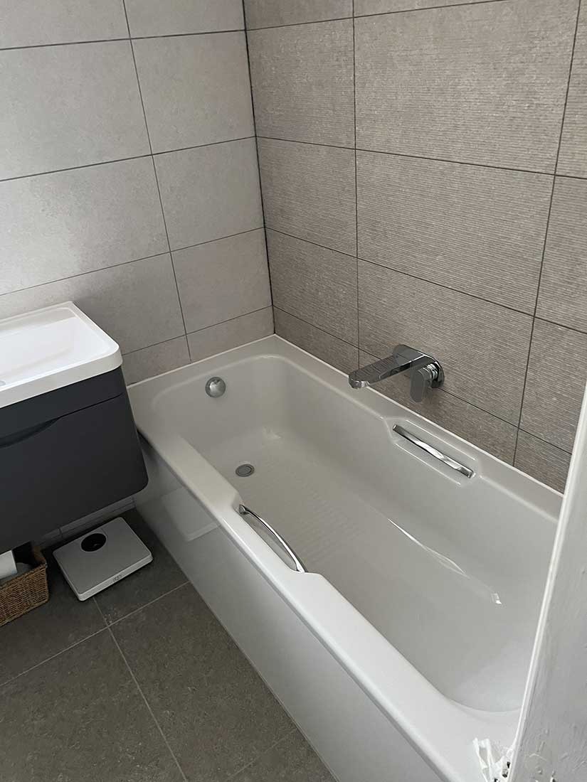 Modern white bath with chrome fixtures installed by Overflow bathroom fitters in Bracknell